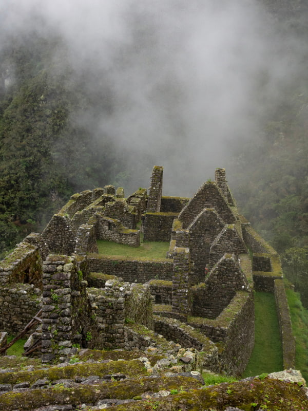 Fog covering the lush green mountains of the Andes, creating a mystical and dramatic landscape near Machu Picchu.