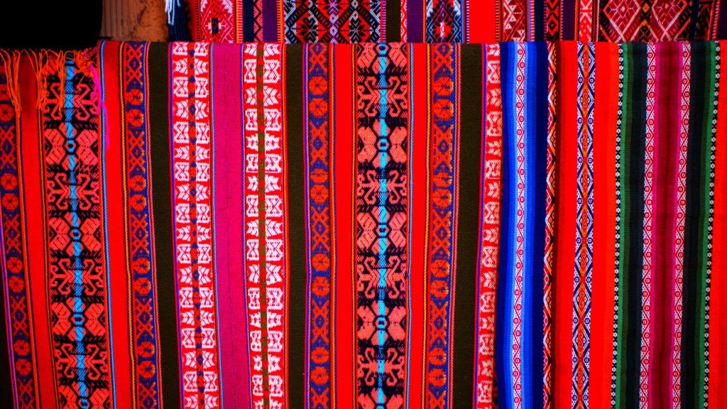 Colorful Andean textiles with traditional designs, showcasing the rich cultural and textile heritage of the Peruvian Andes - Xplor Machu Picchu.