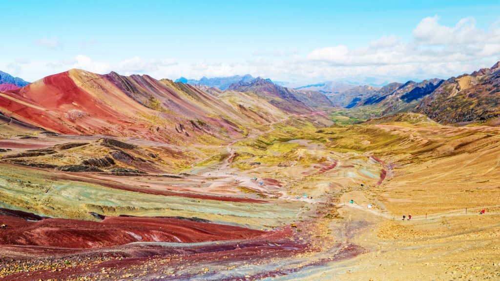 Vibrant multicolored mountains and valleys in the Peruvian Andes with a clear blue sky - Xplor MachuPicchu