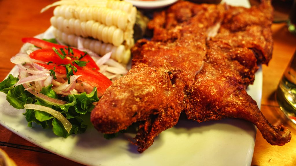 Traditional Peruvian fried guinea pig (cuy) served with corn, salad, and potatoes – Xplor MachuPicchu