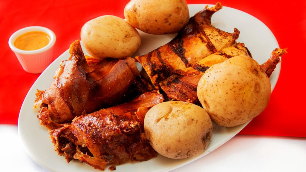 Traditional Peruvian roasted cuy served with potatoes and spicy sauce - Xplor MachuPicchu