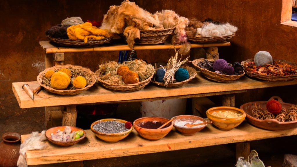 Materiales y tintes naturales utilizados en la artesanía textil andina, mostrando ingredientes tradicionales para el teñido de lanas - Xplor Machu Picchu.