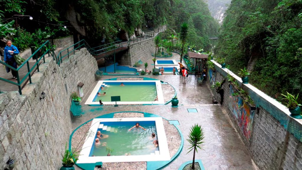 Tourists enjoying the hot springs in the cloud forest, a top spot featured in the Aguas Calientes Guide - Xplor Machu Picchu